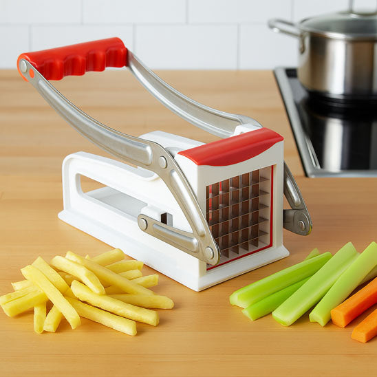 Coupe frites posé sur table à côté de frites.