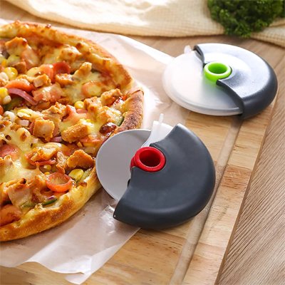 Couteau à pizza posé sur une table en présentation à côté d'une pizza