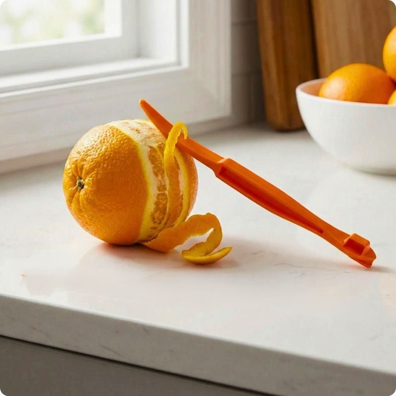 epluche agrume orange posé à cheval sur une orange