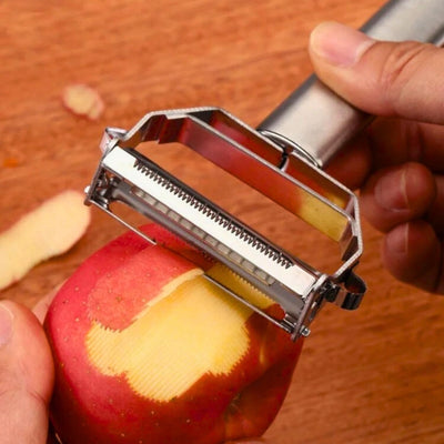 Personne en train d'éplucher une pomme au-dessus d'une table, des épluchures sont déjà sur la table.