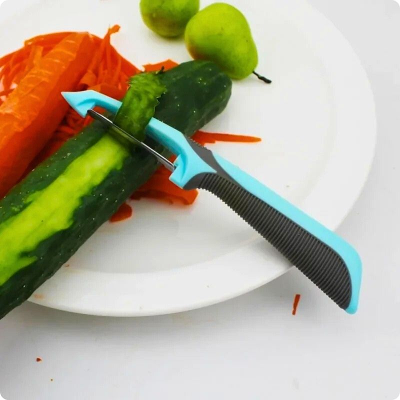 Eplucheur legume bleu et noir posé dans une assiette avec une épluchure de concombre dans la lame.