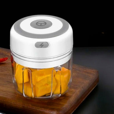 Hachoir électrique blanc posé sur une planche à découper en bois.