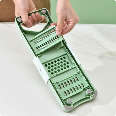 Mandoline cuisine avec ustensiles placés dans un système de rangement intégré.