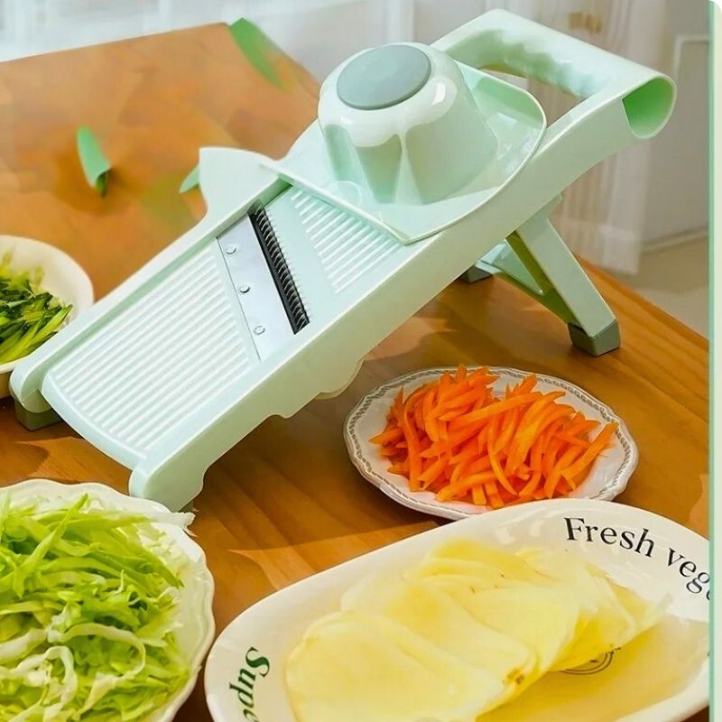 Mandoline japonaise posée sur table côté plats légumes variés