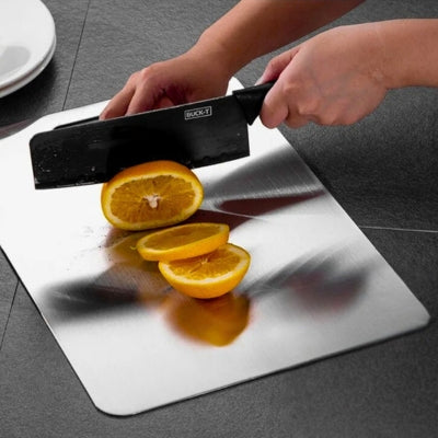planche à découper inox utilisée par une personne pour couper des citrons.