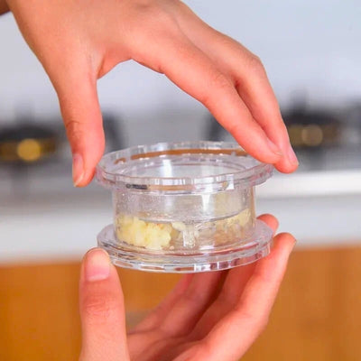 Presse ail tenue en les mains d'une personne.