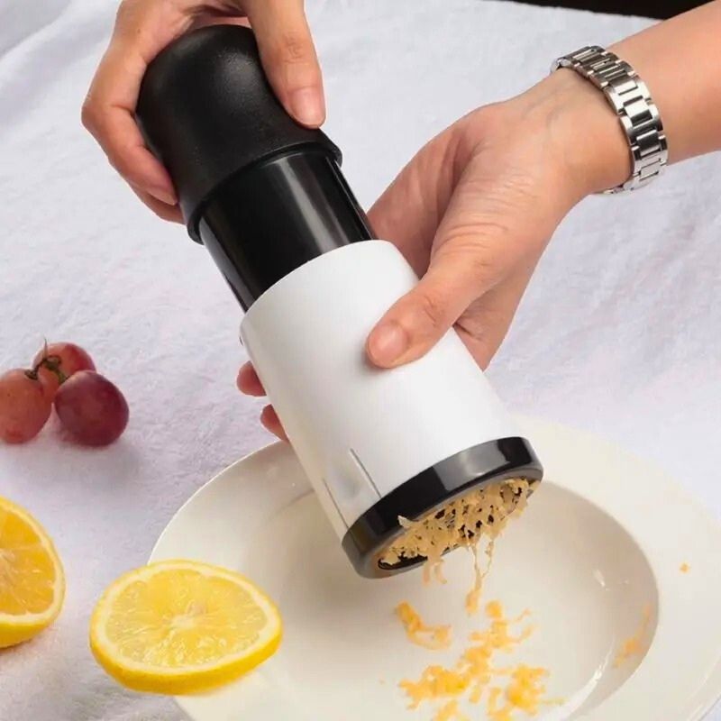 Râpe à fromage utilisée pour râper du fromage au-dessus d'une assiette.