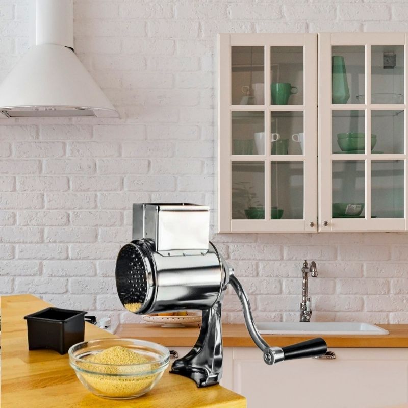 Râpe a fromage derrière un bol de fromage râpé.