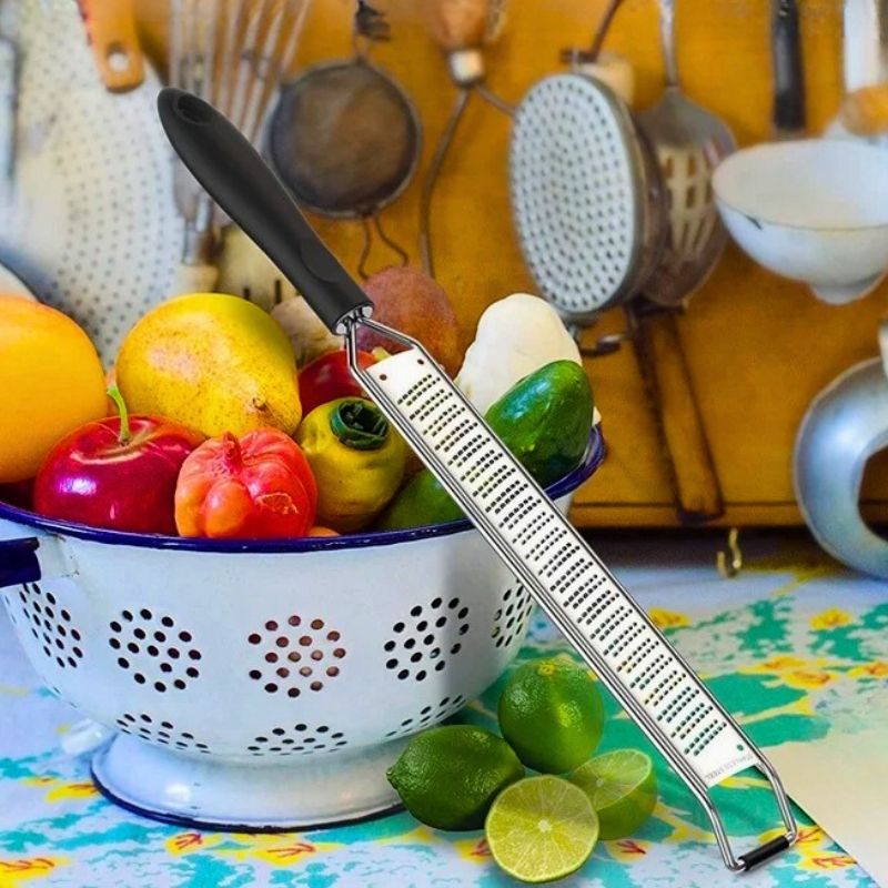 Zesteur posé à cheval sur une table et une passoire.