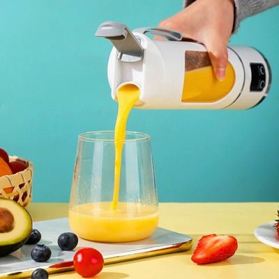 Personne versant jus d'orange mixé à l'aide d'un Blender mini.