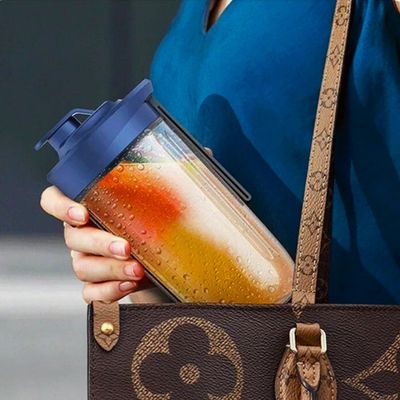 Personne mettant dans son sac le réservoir d'un mini blender.