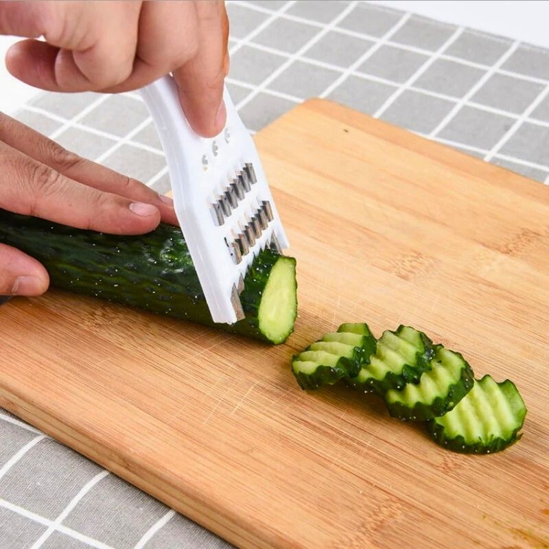 Personne coupant un concombre en tranches dentelées avec une râpe à légumes