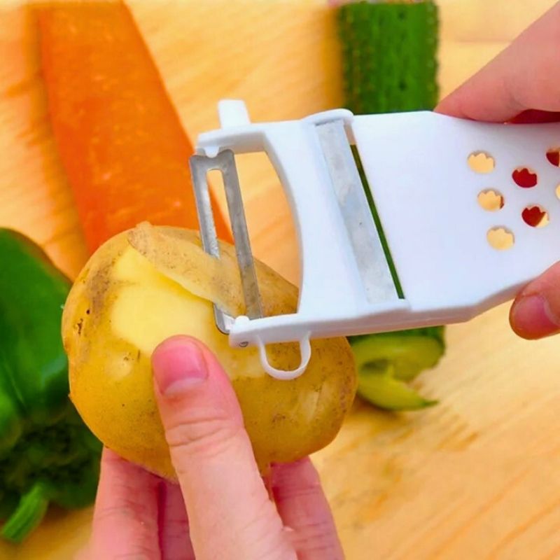 Personne épluchant une pomme de terre avec une râpe multifonction.