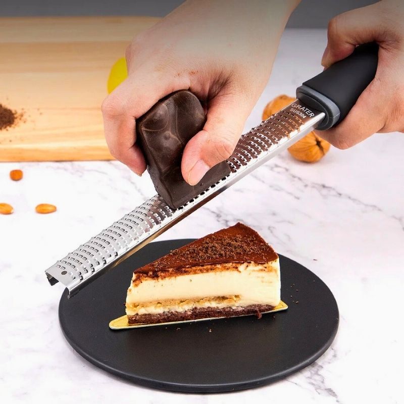 Personne qui utilise une zesteur pour râper du chocolat