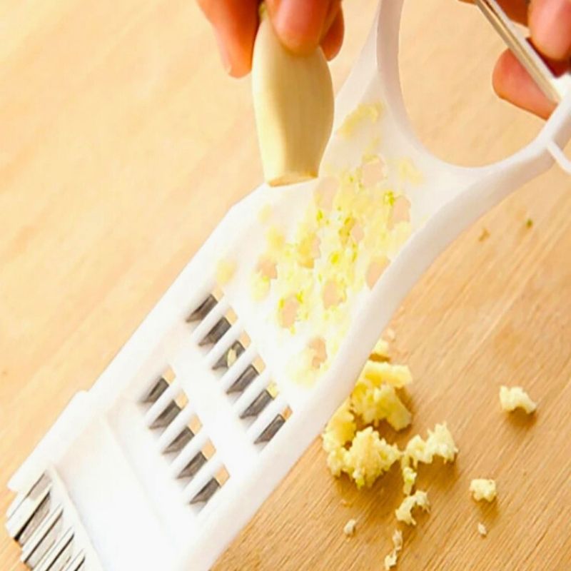 Personne râpant de l'ail avec une râpe.