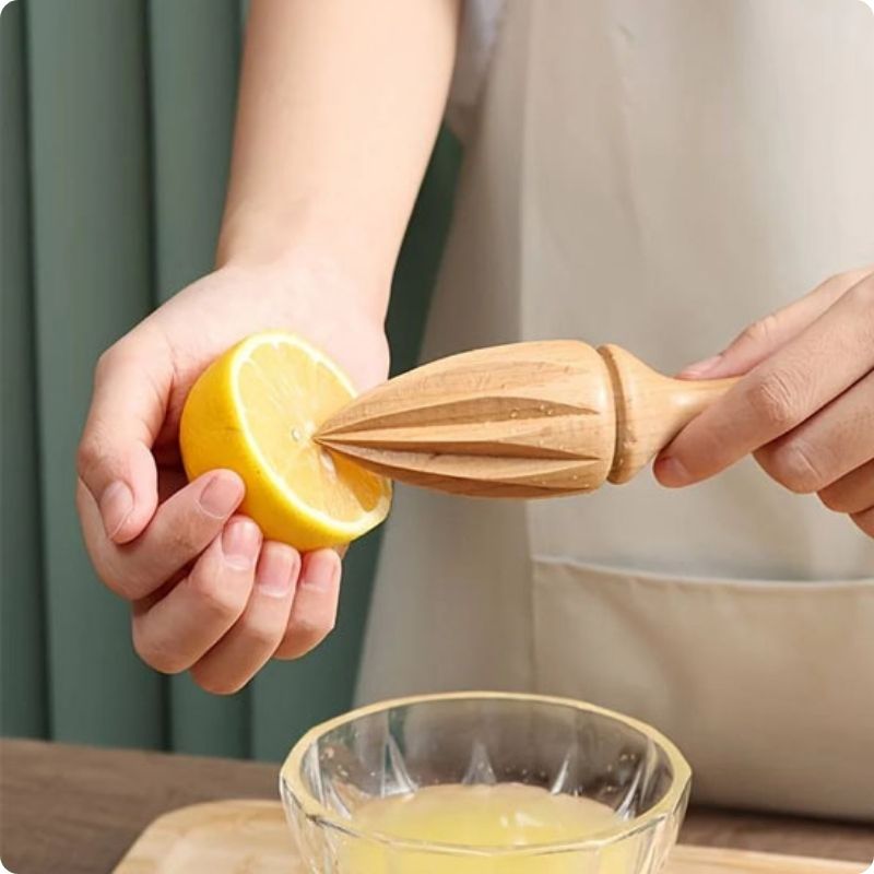 Personne utilisant un presse citron manuel pour presser un citron.