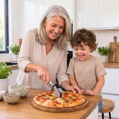 Roulette à pizza double inox'ine utilisée par une femme avec son petit fils en cuisine