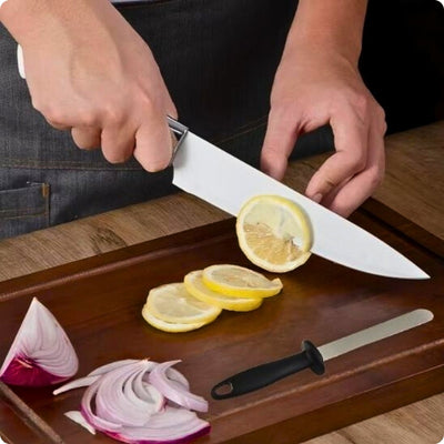 Affuteur de couteaux posé à côté d'une personne qui coupe un citron à l'aide d'un couteau.