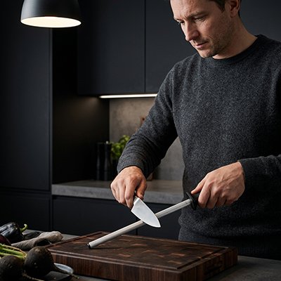 Aiguiseur de couteau tranche f'ine utilisé par un homme qui aiguise un couteau