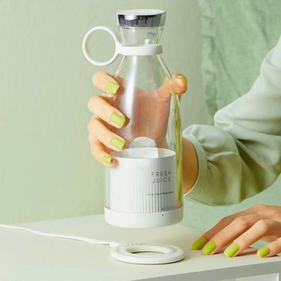 Personne posant un blender portable sur son système de charge.