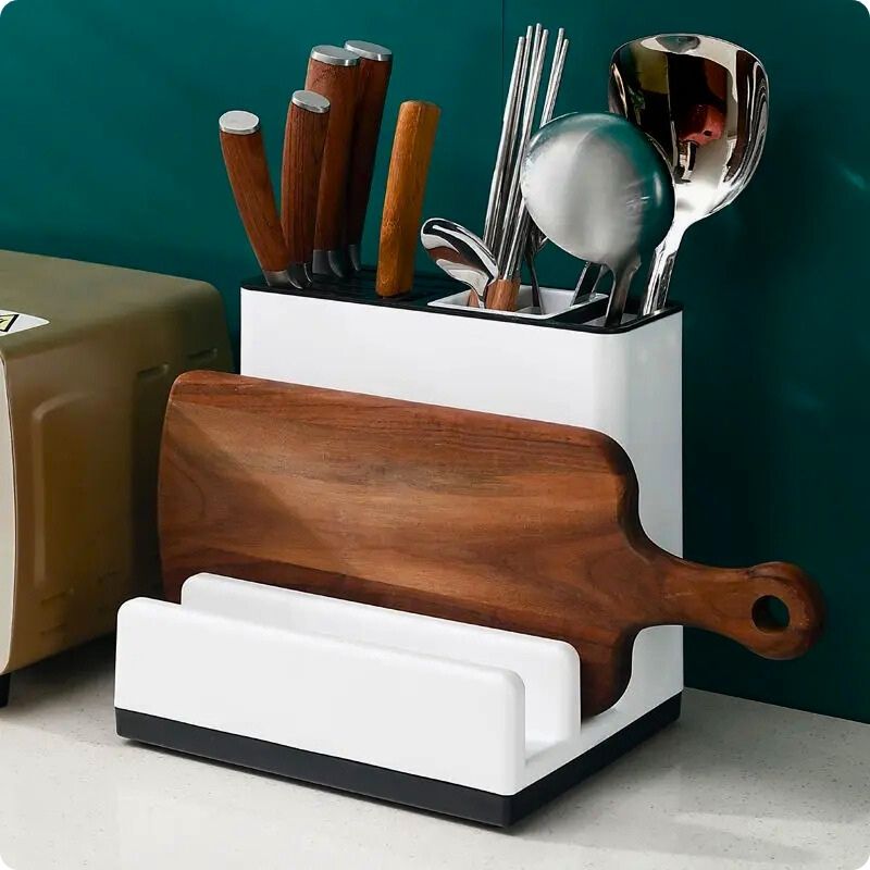 Bloc couteaux sur table avec planche et ustensiles.