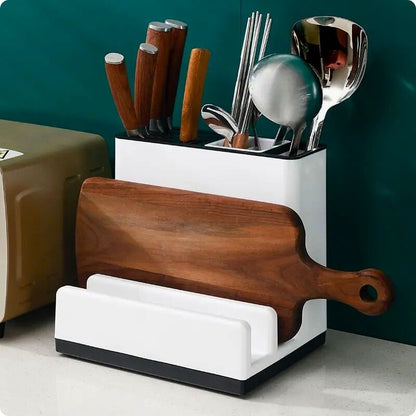 Bloc couteaux sur table avec planche et ustensiles.