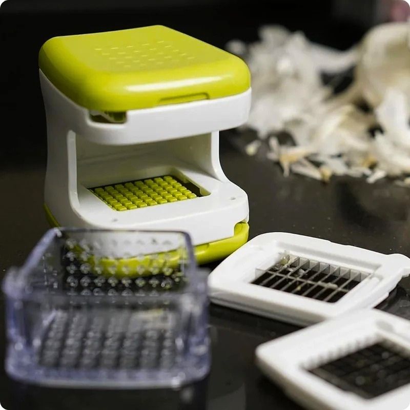coupe ail clic ail'ine posé sur table avec ses accessoires