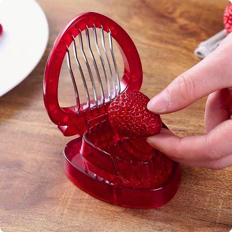 Coupe fraise frais'ine avec une main posant une fraise dessus