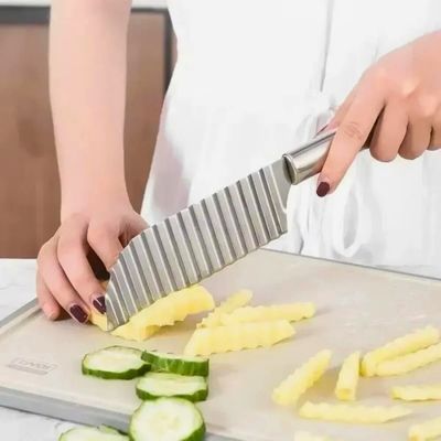 Personne coupant des frites ondulées avec un coupe frite