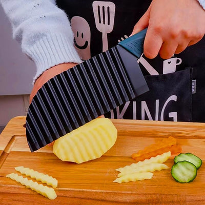 Personne en train de couper une pomme de terre avec un coupe frite avec lame ondulée de couleur noire