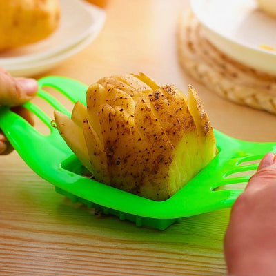 Mains qui coupe une pomme de terre en frite grâce au coupe frite emport'ine vert