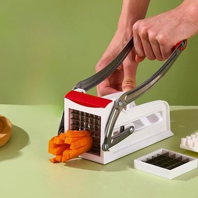 Personne utilisant un coupe frite professionnel pour couper une carotte en frite