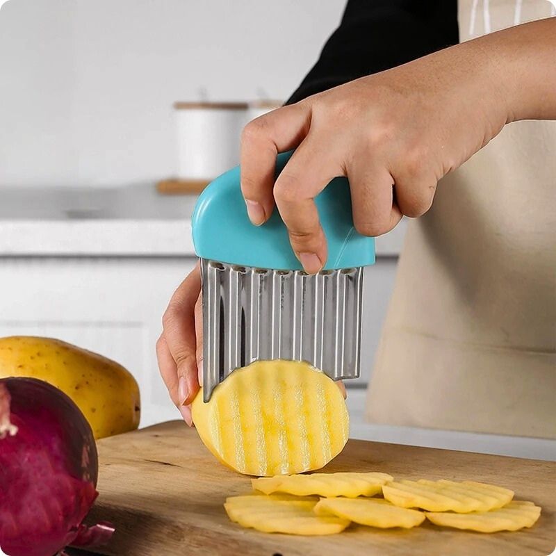 Coupe frites manuel tranchant une rondelle ondulée de pomme de terre.