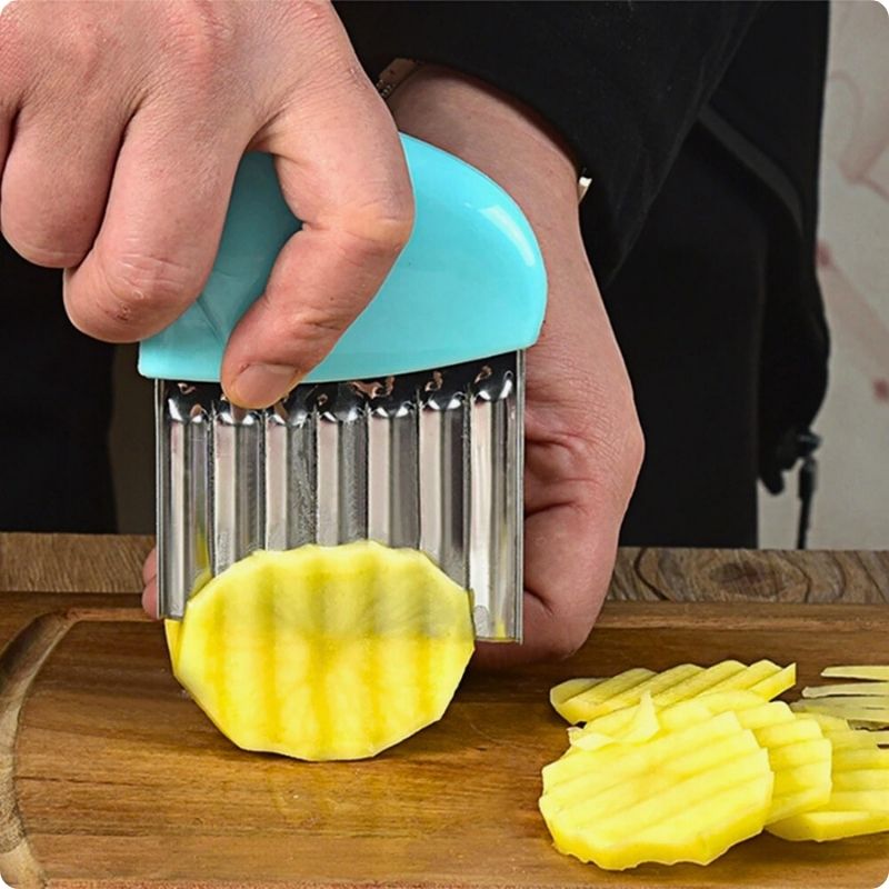 Personne tranchant une rondelle ondulées de pomme de terre avec un coupe frites manuel