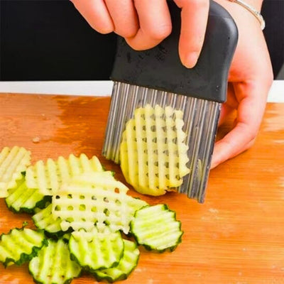 Mains-qui-coupe-une-pomme-de-terre-en-rondelle-avec-un-coupe-frites-manuel-dentelé