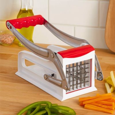 Coupe frites sur table à côté de légumes coupés en frites.