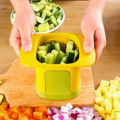 coupe légumes sur table avec concombre coupé en bâtonnet dedans.