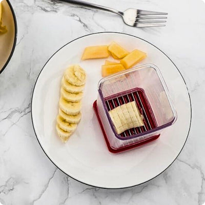 Coupe légumes manuel posé dans une assiette avec un morceau de banane dedans.