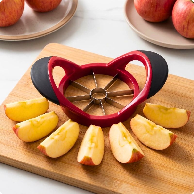 Coupe pomme octo'ine posé sur une planche avec des quartiers de pomme