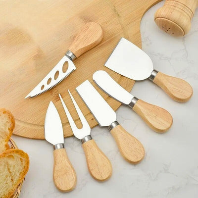 Ensemble de 6 couteaux à fromage posé sur une planche à découper en bois. 