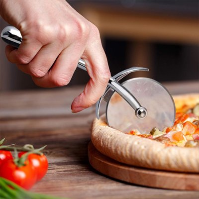 Couteau à pizza utilisé par une femme pour couper une pizza