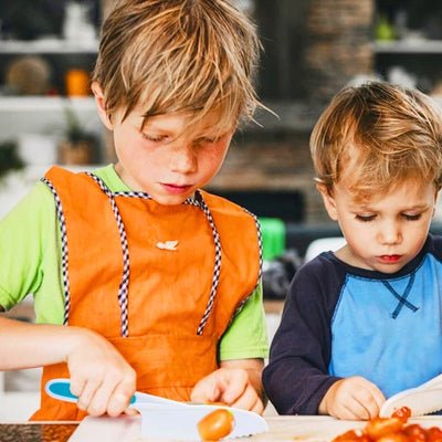 Enfant coupant une tomate avec un couteau cuisine enfant