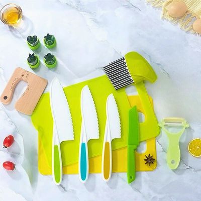 couteau cuisine enfant posé sur table avec des ustensiles de cuisine pour enfant