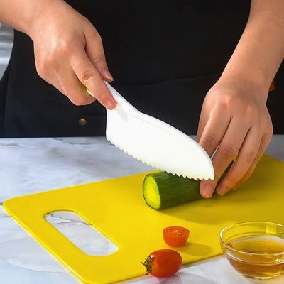 Personne coupant un concombre avec un couteau enfant