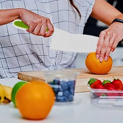Couteau pour enfant coutranquil'ine utilisé pour couper une orange