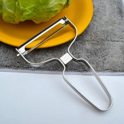Économe posé à cheval sur une assiette et sur une table.