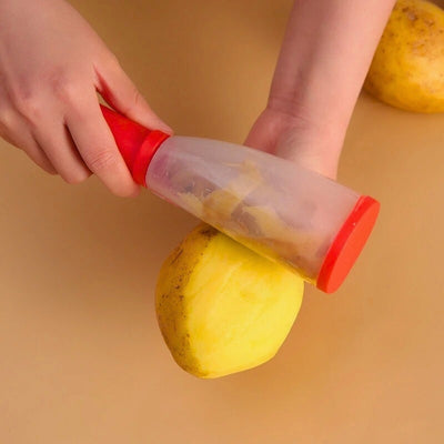 Personne en train d'éplucher une pomme de-terre au-dessus d'une table, les épluchures restent dans le réservoir de l'économe.
