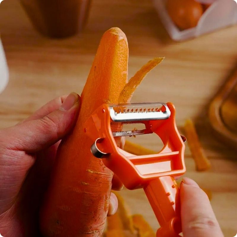 Personne en train d'éplucher une carotte avec un économe à julienne en cuisine.