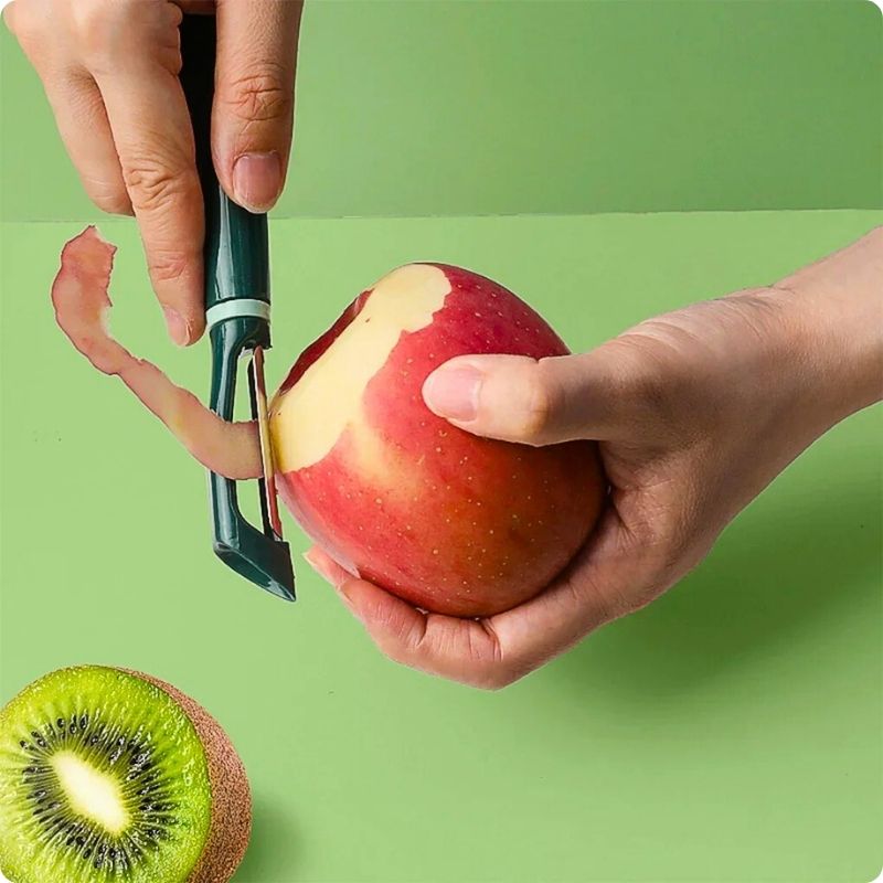 Personne en train d'éplucher une pomme avec un économe cuisine.