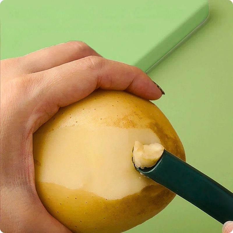 Personne en train de retirer une impureté d'une pomme de terre avec un économe cuisine.